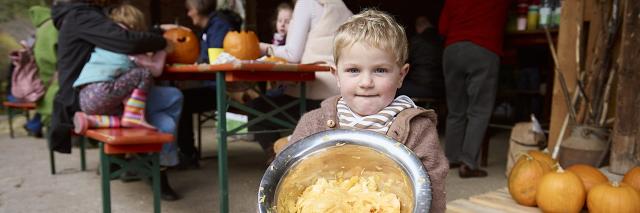 Kind hält eine Schüssel mit Kürbisfleisch
