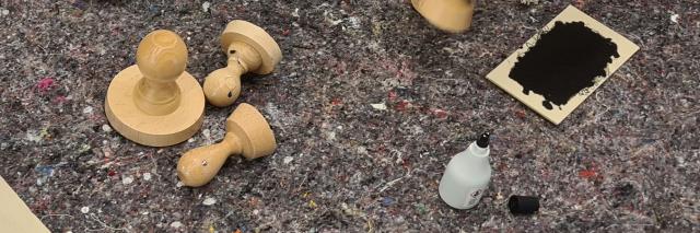 Stempel und Stempelkissen auf grauer Tischdecke