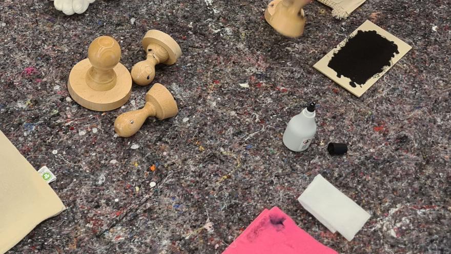 Stempel und Stempelkissen auf grauer Tischdecke